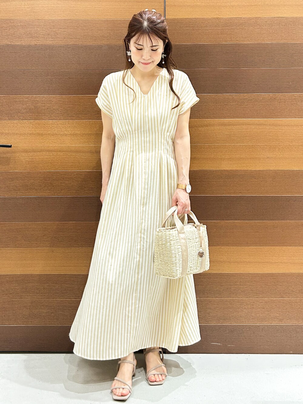 ベージュ系のワンピース、ベージュ系のトートバッグ、ベージュ系のサンダルを着用したレディースの春コーディネートの1枚目の写真