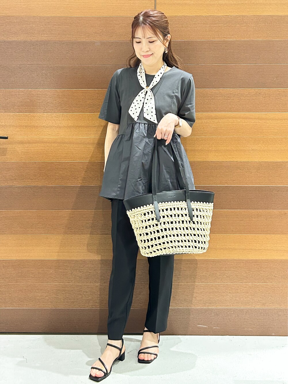 グレー系のTシャツ/カットソー、ブラック系のその他パンツ、ブラウン系のトートバッグを着用したレディースの春コーディネートの1枚目の写真