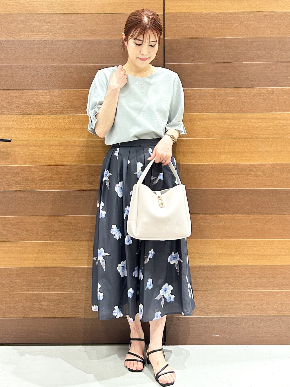 グリーン系のシャツ/ブラウス、グレー系のスカート、グレー系のトートバッグを着用したレディースの夏コーディネートの1枚目の写真