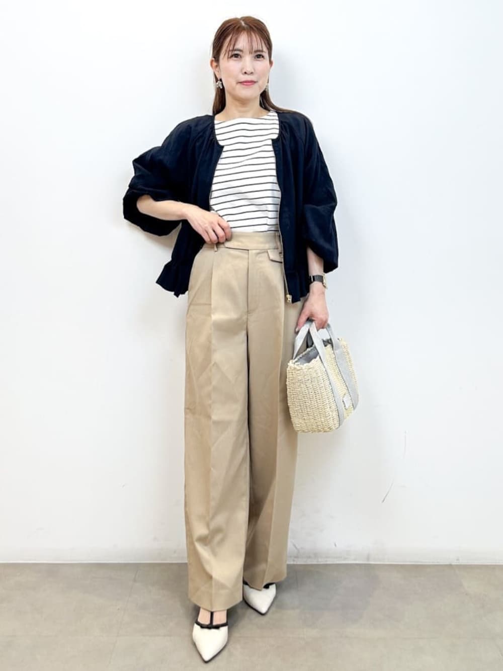 ブルー系のブルゾン、ホワイト系のTシャツ/カットソー、ベージュ系のその他パンツを着用したレディースの春コーディネートの1枚目の写真
