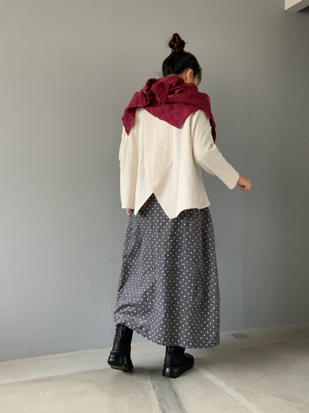 ホワイト系のトップス、グレー系のスカート、ブラック系のブーツを着用したレディースの秋コーディネートの1枚目の写真