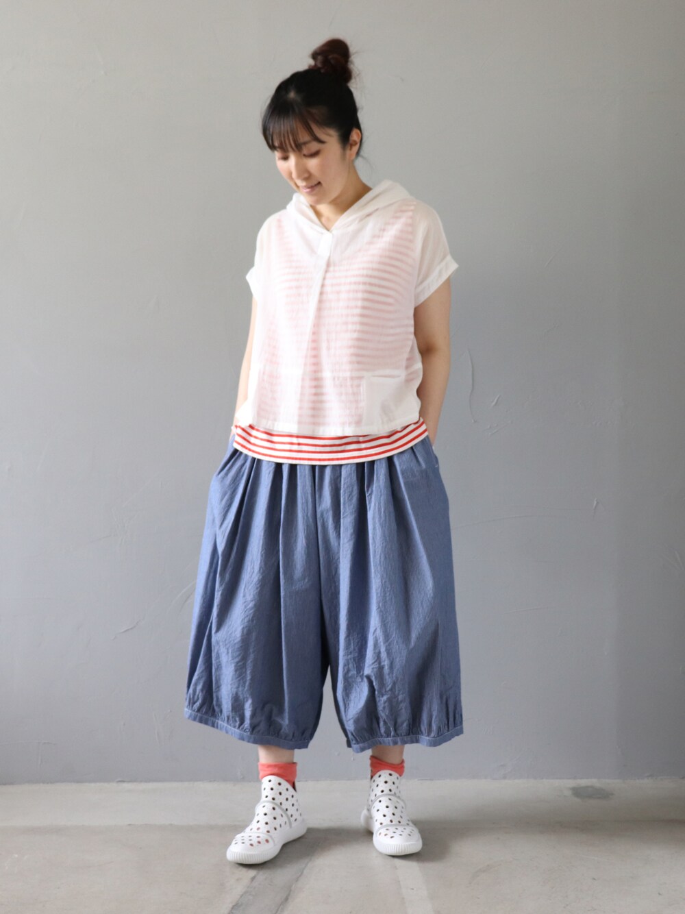 ホワイト系のトップス、レッド系のタンクトップ、ブルー系のパンツを着用したレディースの夏コーディネートの1枚目の写真