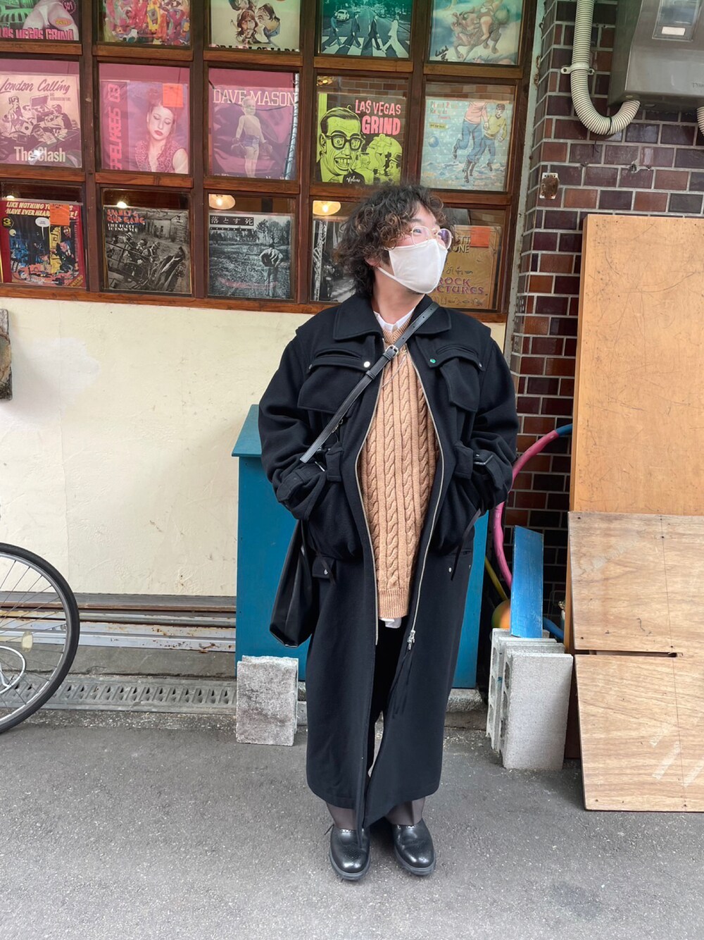 ブラック系のジャケット/アウター、ベージュ系のベスト、ブラウン系のスラックスを着用したメンズの冬コーディネートの1枚目の写真