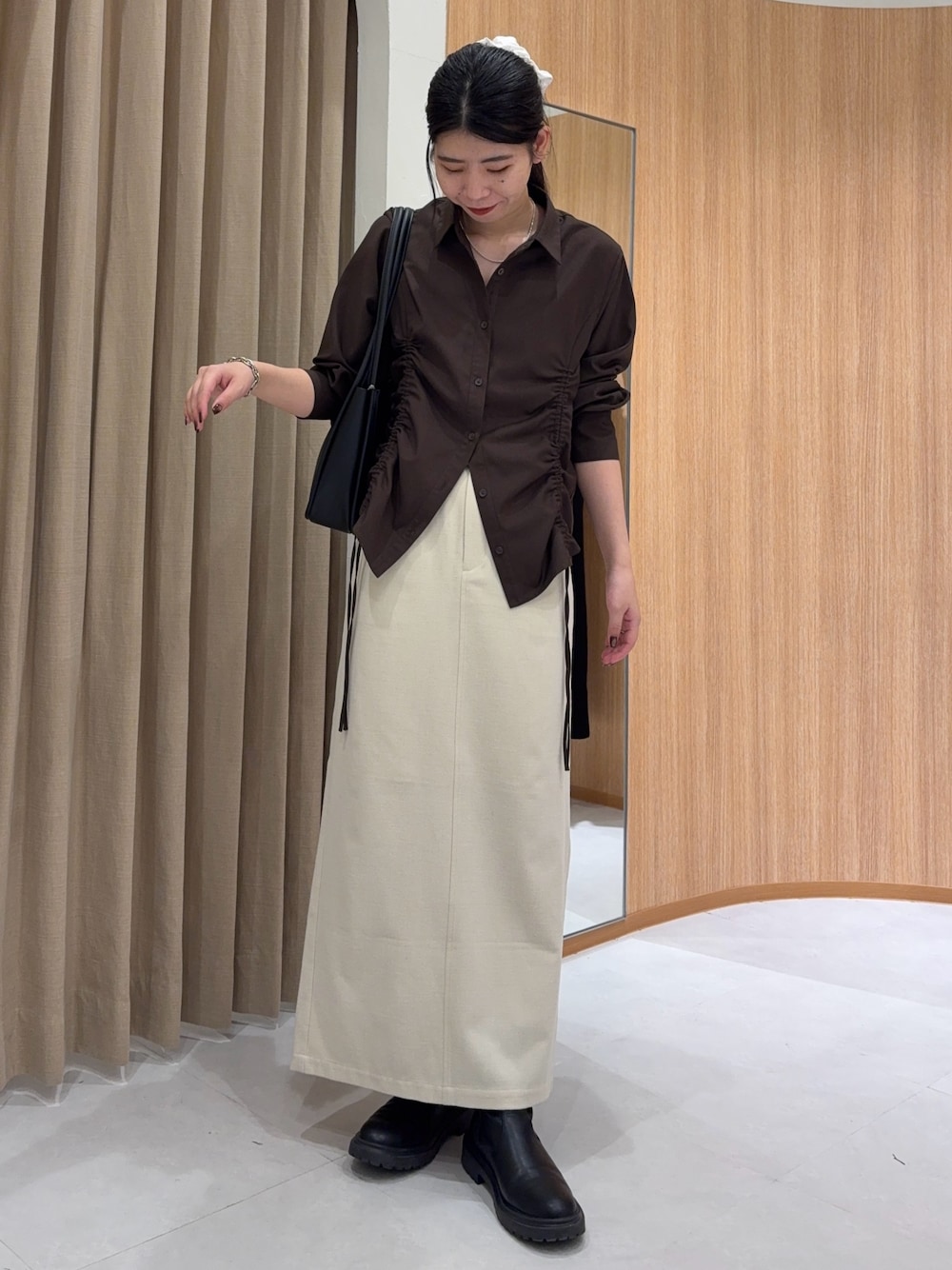 ホワイト系のスカート、ブラウン系のシャツ/ブラウス、ブラック系のショルダーバッグを着用したレディースの秋コーディネートの1枚目の写真