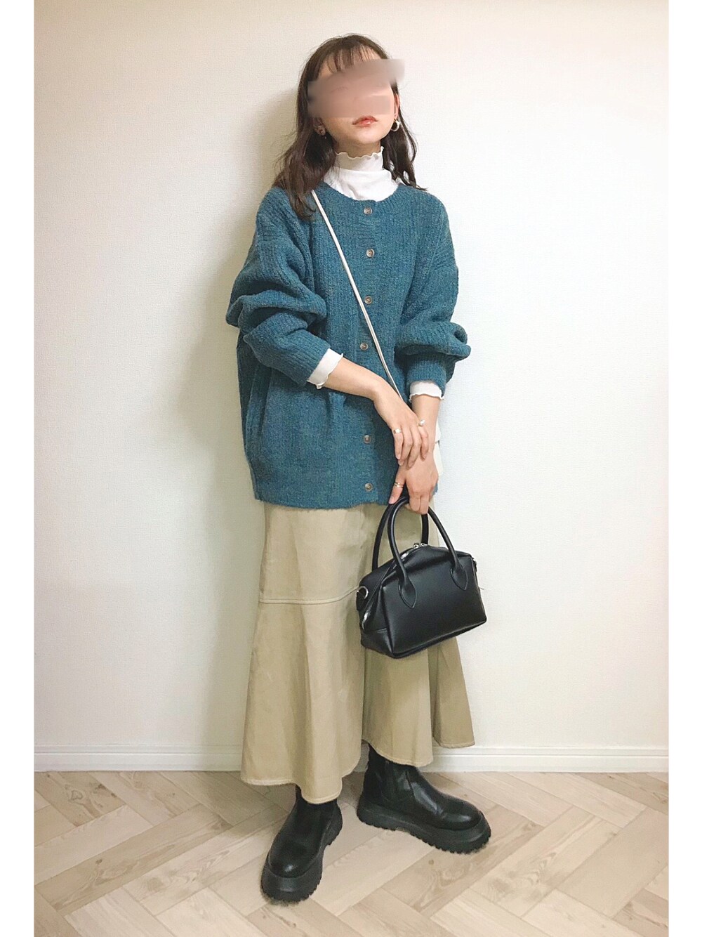 グリーン系のカーディガン/ボレロ、ホワイト系のTシャツ/カットソー、ベージュ系のスカートを着用したレディースの秋コーディネートの1枚目の写真