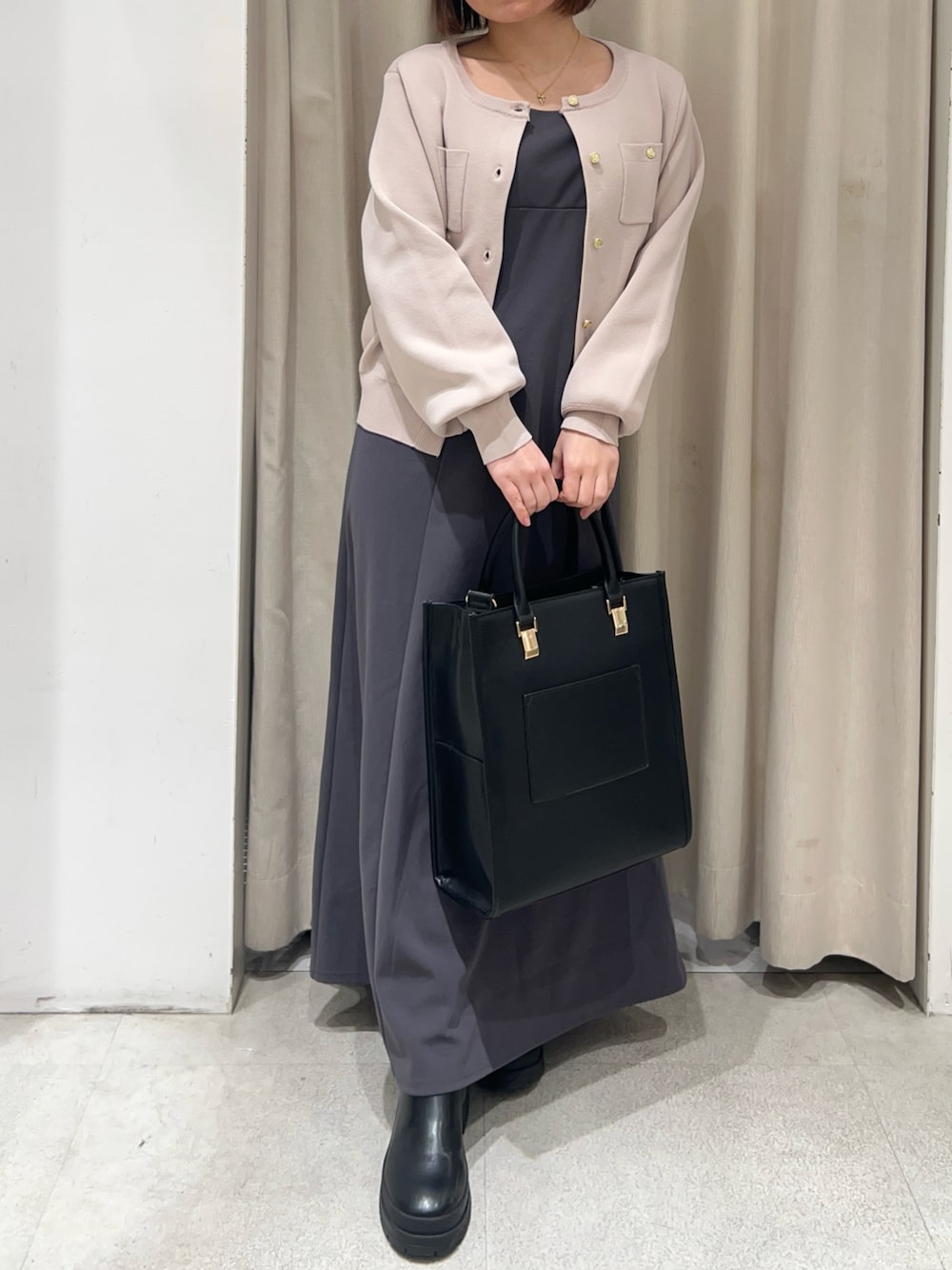 ピンク系のカーディガン/ボレロ、グレー系のワンピース、ブラック系のショルダーバッグを着用したレディースの冬コーディネートの1枚目の写真