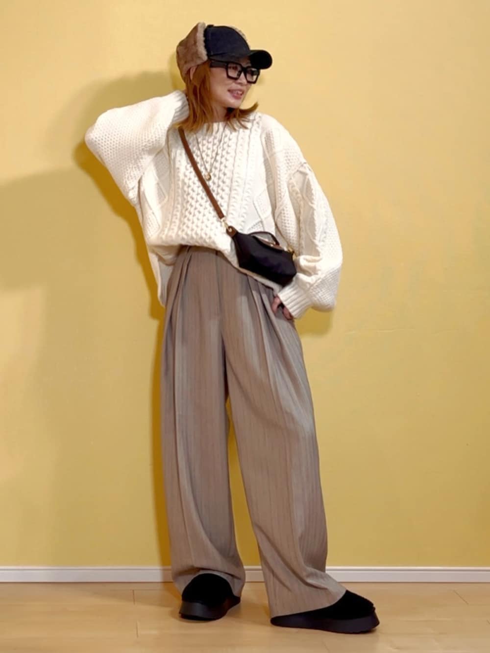 ホワイト系のニット/セーター、ベージュ系のその他パンツ、ブラック系のショルダーバッグを着用したレディースの秋コーディネートの1枚目の写真