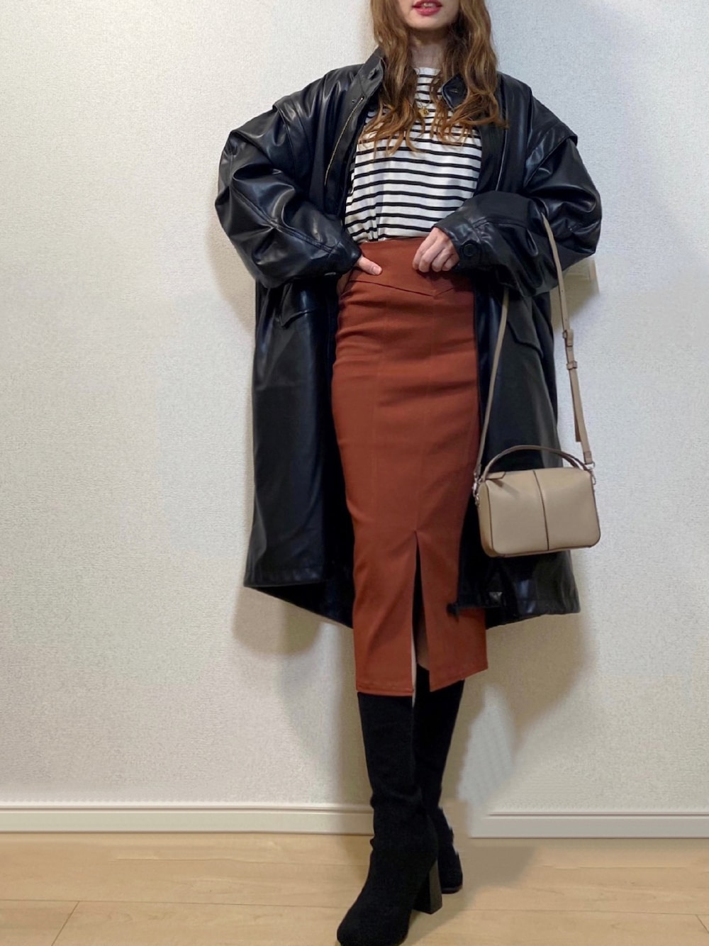 ブラック系のモッズコート、ブラウン系のスカート、ブラック系のTシャツ/カットソーを着用したレディースの秋コーディネートの1枚目の写真