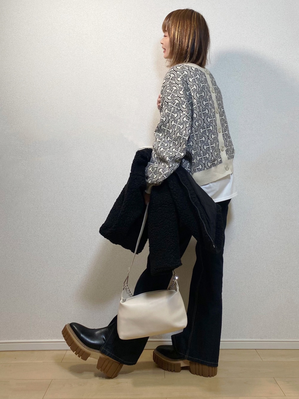 ホワイト系のカーディガン/ボレロ、ブルー系のデニムパンツ、ブラック系のジャケット/アウターを着用したレディースの冬コーディネートの1枚目の写真