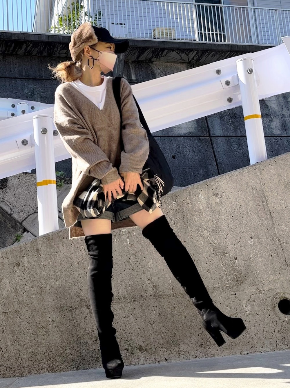 ベージュ系のニット/セーター、ブラック系のブーツ、ブラック系のTシャツ/カットソーを着用したレディースの秋コーディネートの1枚目の写真