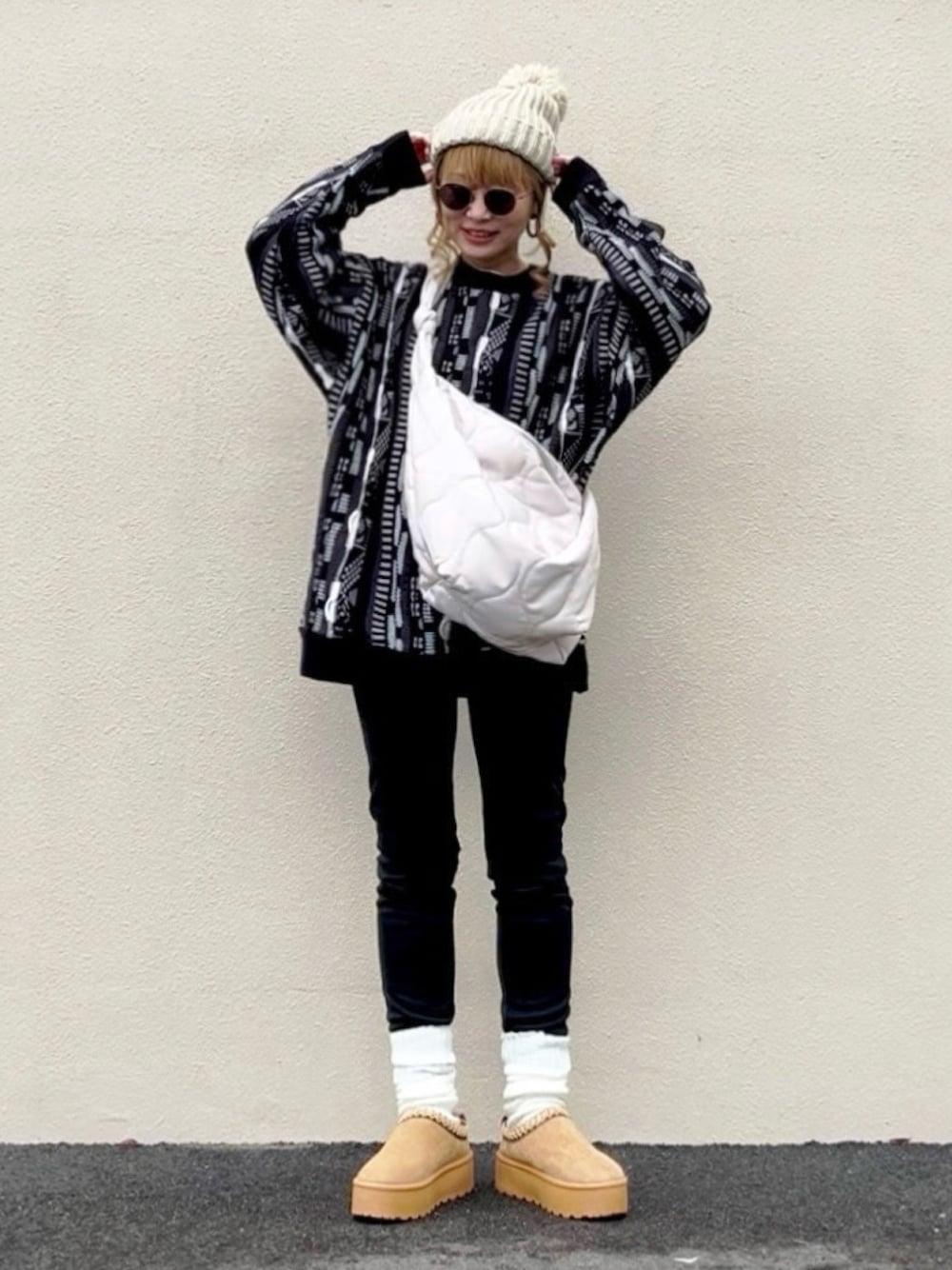 ブラック系のニット/セーター、ホワイト系のショルダーバッグ、ベージュ系のシューズを着用したレディースの冬コーディネートの1枚目の写真