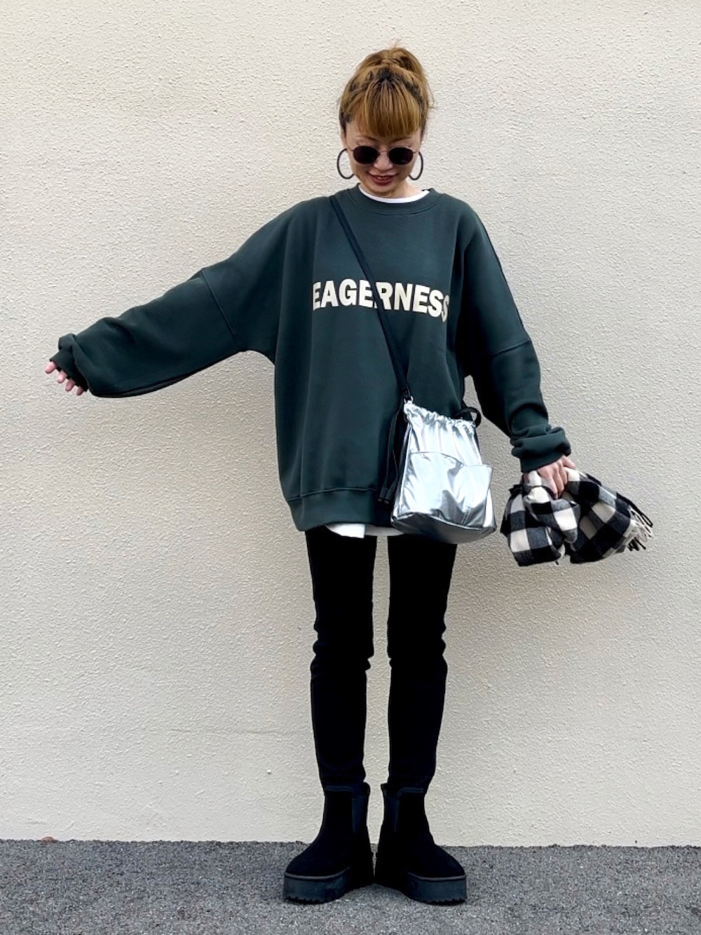 グリーン系のスウェット、ブラック系のブーツ、シルバー系のハンドバッグを着用したレディースの秋コーディネートの1枚目の写真