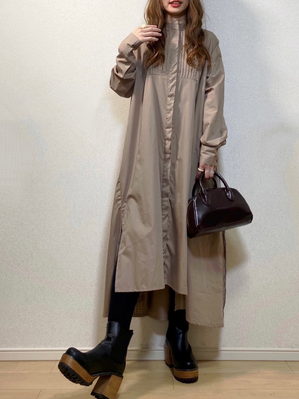 ベージュ系のワンピース、ブラウン系のショルダーバッグ、ブラック系のブーツを着用したレディースの秋コーディネートの1枚目の写真