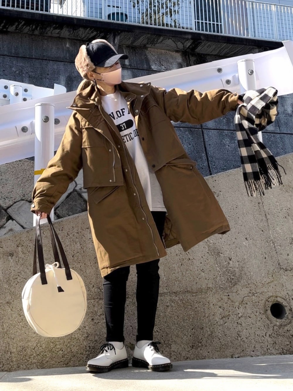 グリーン系のミリタリージャケット、ホワイト系のTシャツ/カットソー、ブラック系のデニムパンツを着用したレディースの冬コーディネートの1枚目の写真