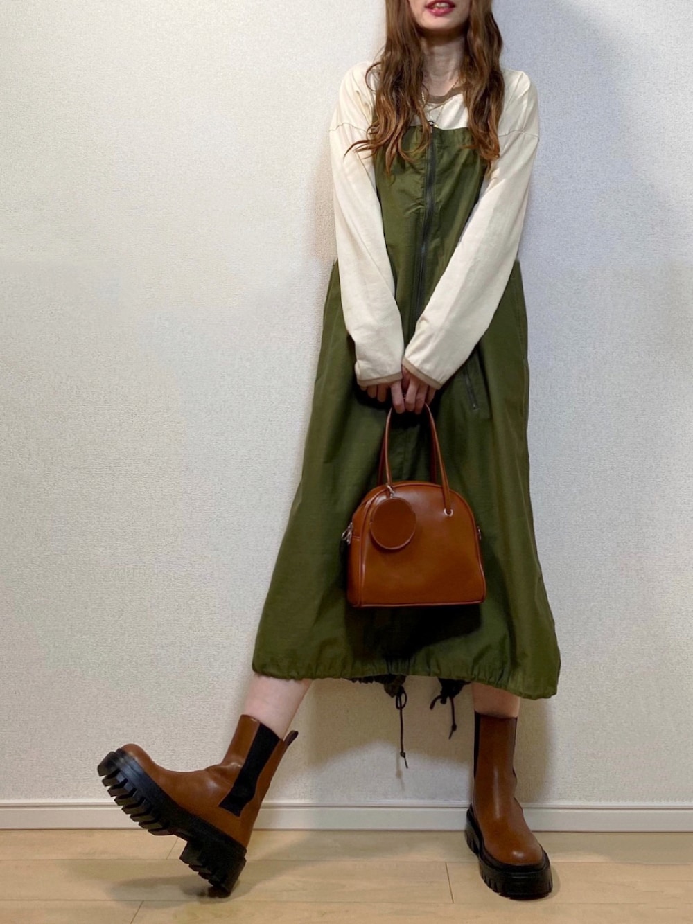 ホワイト系のTシャツ/カットソー、グリーン系のサロペット/オーバーオール、ブラウン系のブーツを着用したレディースの秋コーディネートの1枚目の写真
