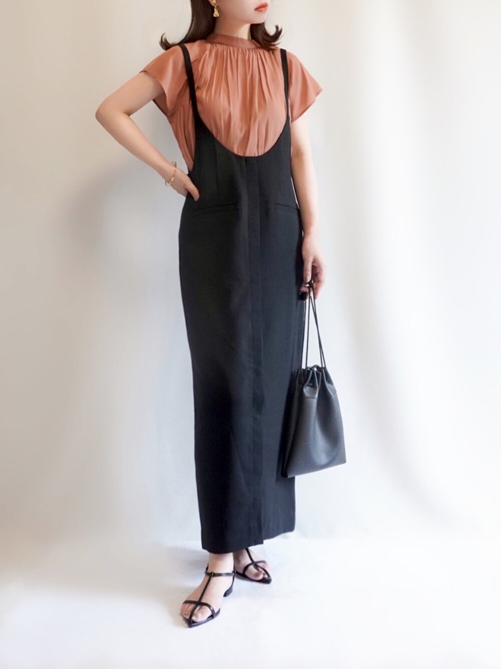 ブラック系のスカート、ブラック系のサンダル、レッド系のシャツ/ブラウスを着用したレディースの夏コーディネートの1枚目の写真