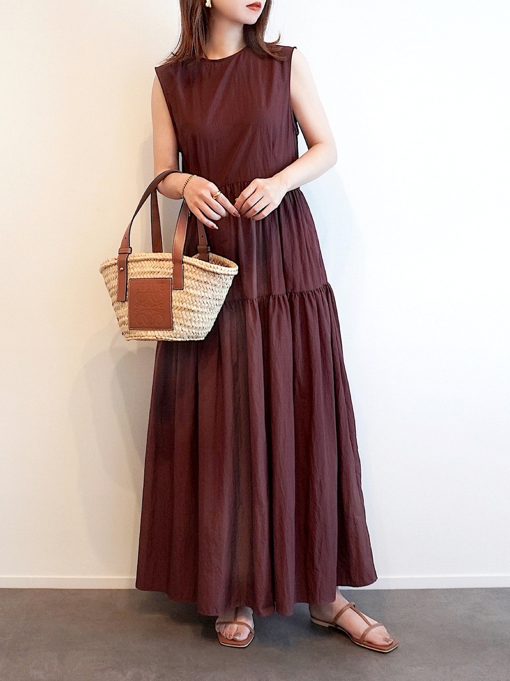 ブラウン系のワンピース、イエロー系のサンダル、ベージュ系のかごバッグを着用したレディースの夏コーディネートの1枚目の写真