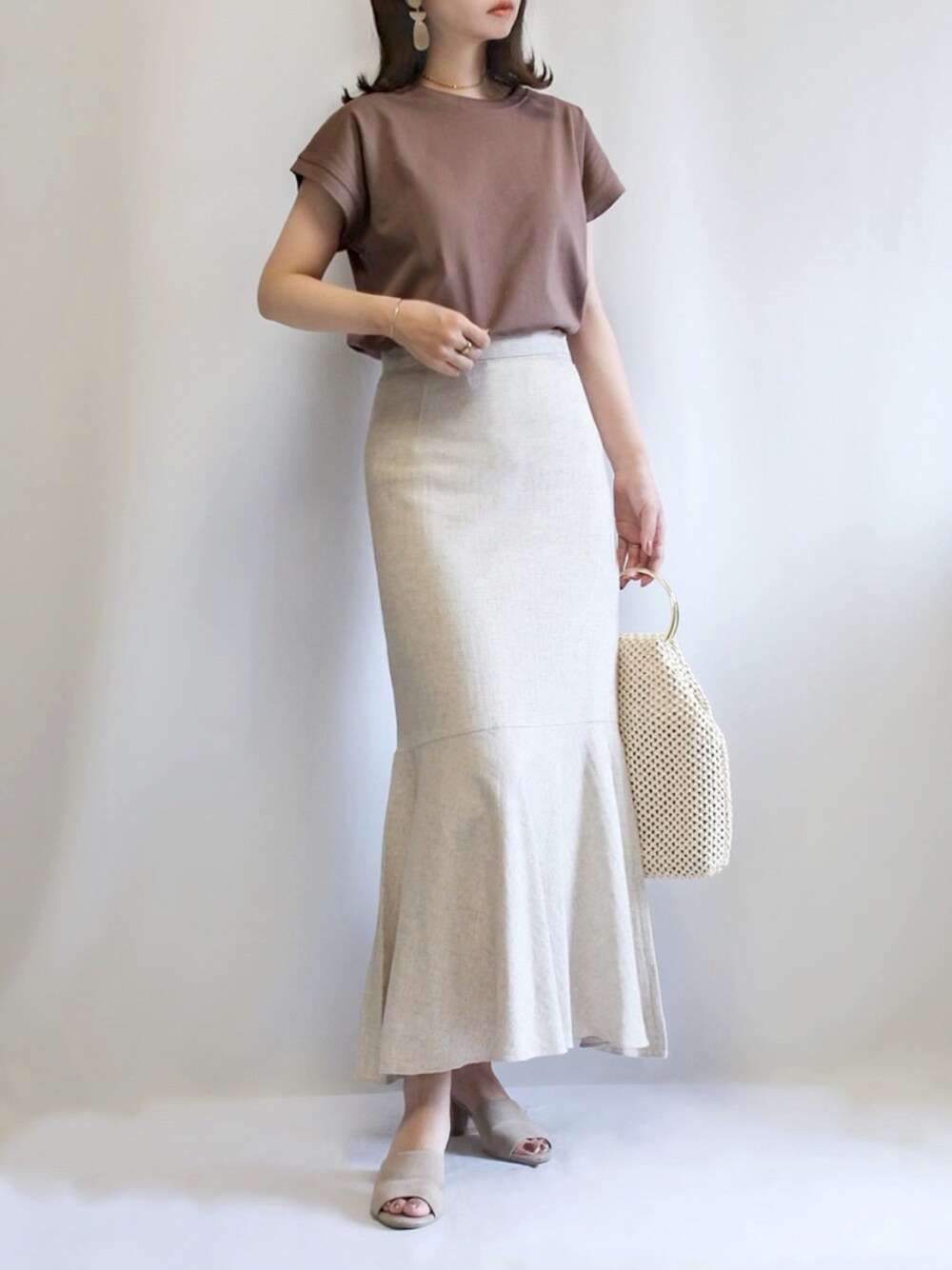 ブラウン系のTシャツ/カットソー、ベージュ系のスカート、ベージュ系のサンダルを着用したレディースの夏コーディネートの1枚目の写真