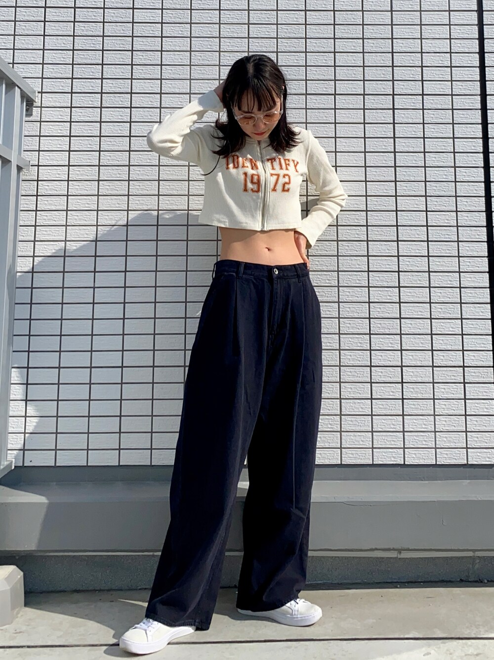 ベージュ系のカーディガン/ボレロ、ブラック系のデニムパンツ、ホワイト系のスニーカーを着用したレディースの春コーディネートの1枚目の写真