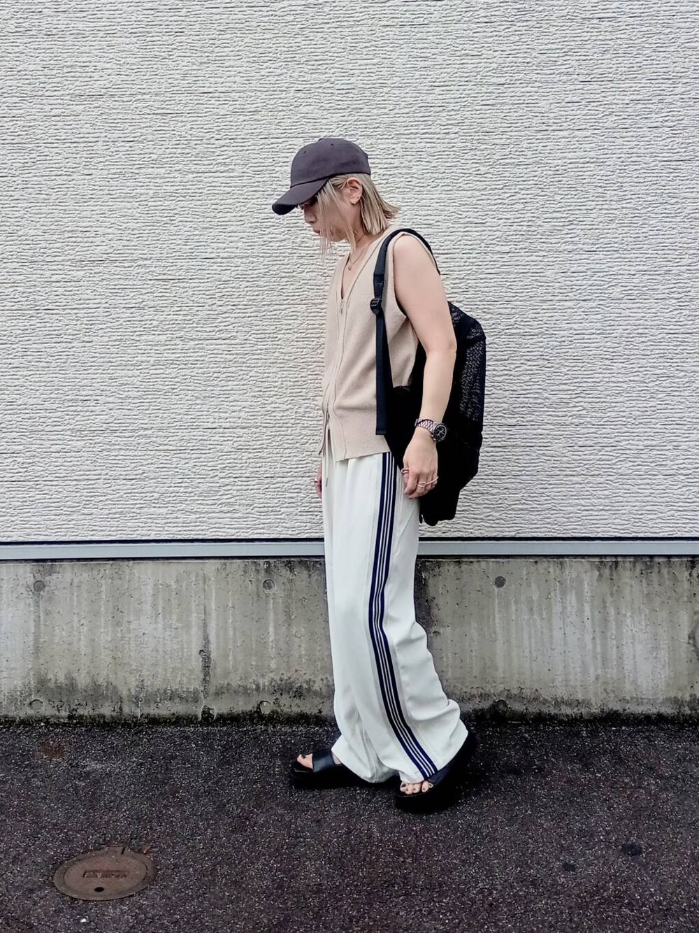 ブラック系のバックパック/リュック、ホワイト系のその他パンツ、ベージュ系のベストを着用したレディースの夏コーディネートの1枚目の写真