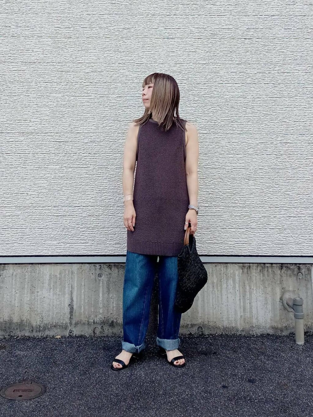 ブラック系のトートバッグ、ブルー系のデニムパンツ、ブラック系のニット/セーターを着用したレディースの夏コーディネートの1枚目の写真