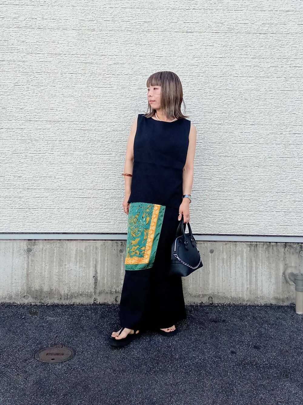 ブラック系のサロペット/オーバーオール、ブラック系のボストンバッグ、ブラック系のサンダルを着用したレディースの夏コーディネートの1枚目の写真