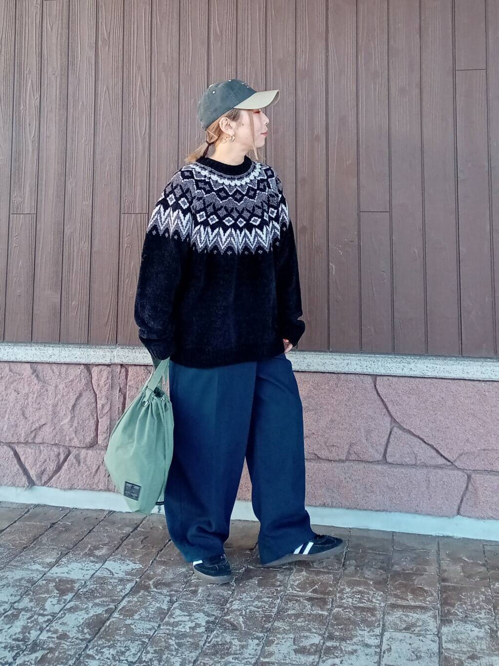 ブルー系のその他パンツ、グリーン系のショルダーバッグ、ブラック系のニット/セーターを着用したレディースの冬コーディネートの1枚目の写真