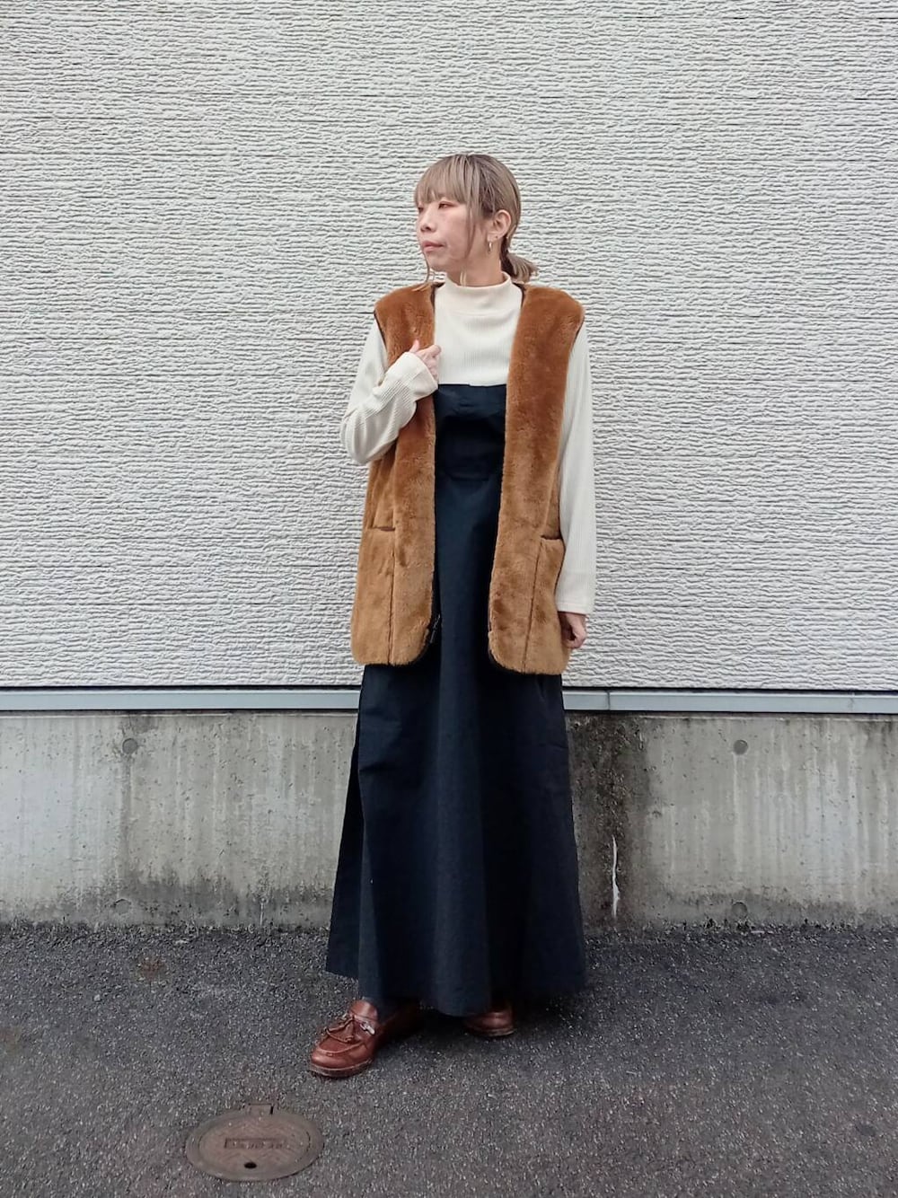 ブラウン系のその他アウター、ブラック系のワンピースを着用したレディースの冬コーディネートの1枚目の写真