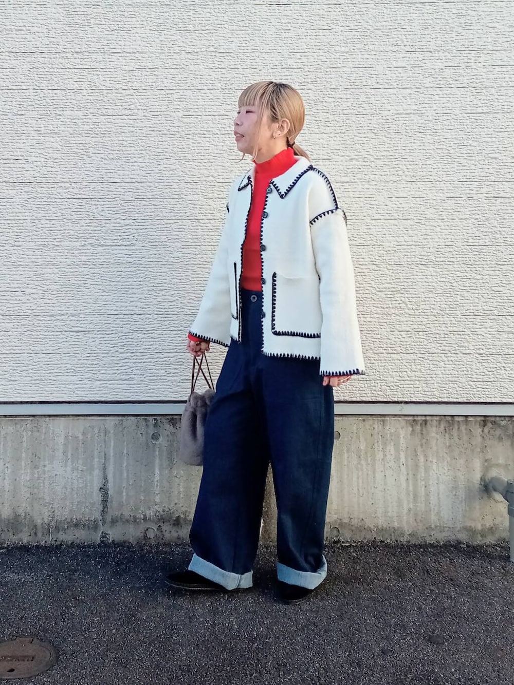 レッド系のニット/セーター、ブルー系のデニムパンツ、ホワイト系のその他アウターを着用したレディースの冬コーディネートの1枚目の写真