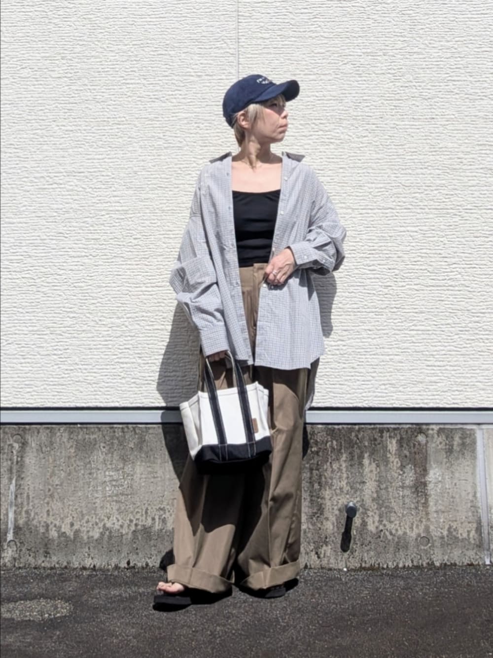 ブルー系のシャツ/ブラウス、ベージュ系のチノパンツ、ブラック系のトートバッグを着用したレディースの秋コーディネートの1枚目の写真