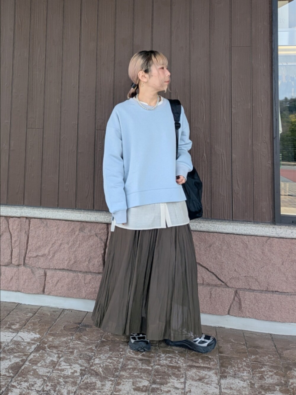 ベージュ系のシャツ/ブラウス、ブラウン系のスカート、ブルー系のTシャツ/カットソーを着用したレディースの春コーディネートの1枚目の写真