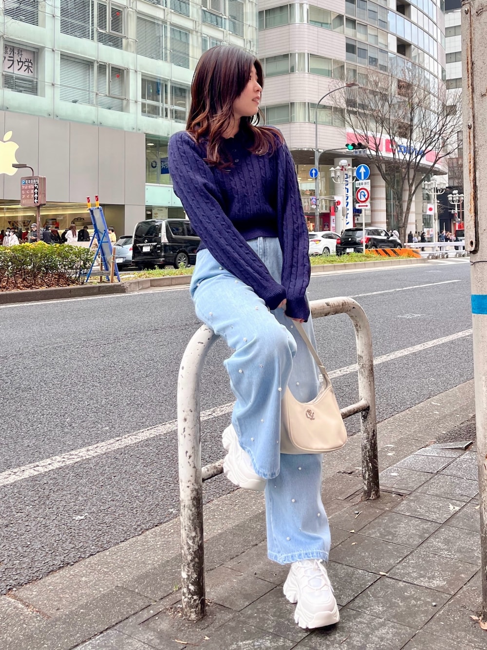 ブルー系のデニムパンツ、ホワイト系のショルダーバッグ、ホワイト系のスニーカーを着用したレディースの冬コーディネートの1枚目の写真