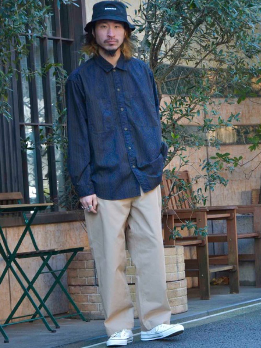 ブルー系のシャツ/ブラウス、ベージュ系のチノパンツ、ホワイト系のスニーカーを着用したメンズの春コーディネートの1枚目の写真