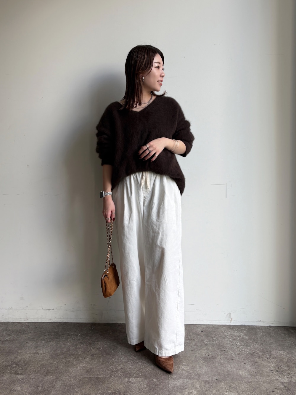 ブラウン系のニット/セーター、イエロー系のショルダーバッグ、ホワイト系のその他パンツを着用したレディースの冬コーディネートの1枚目の写真