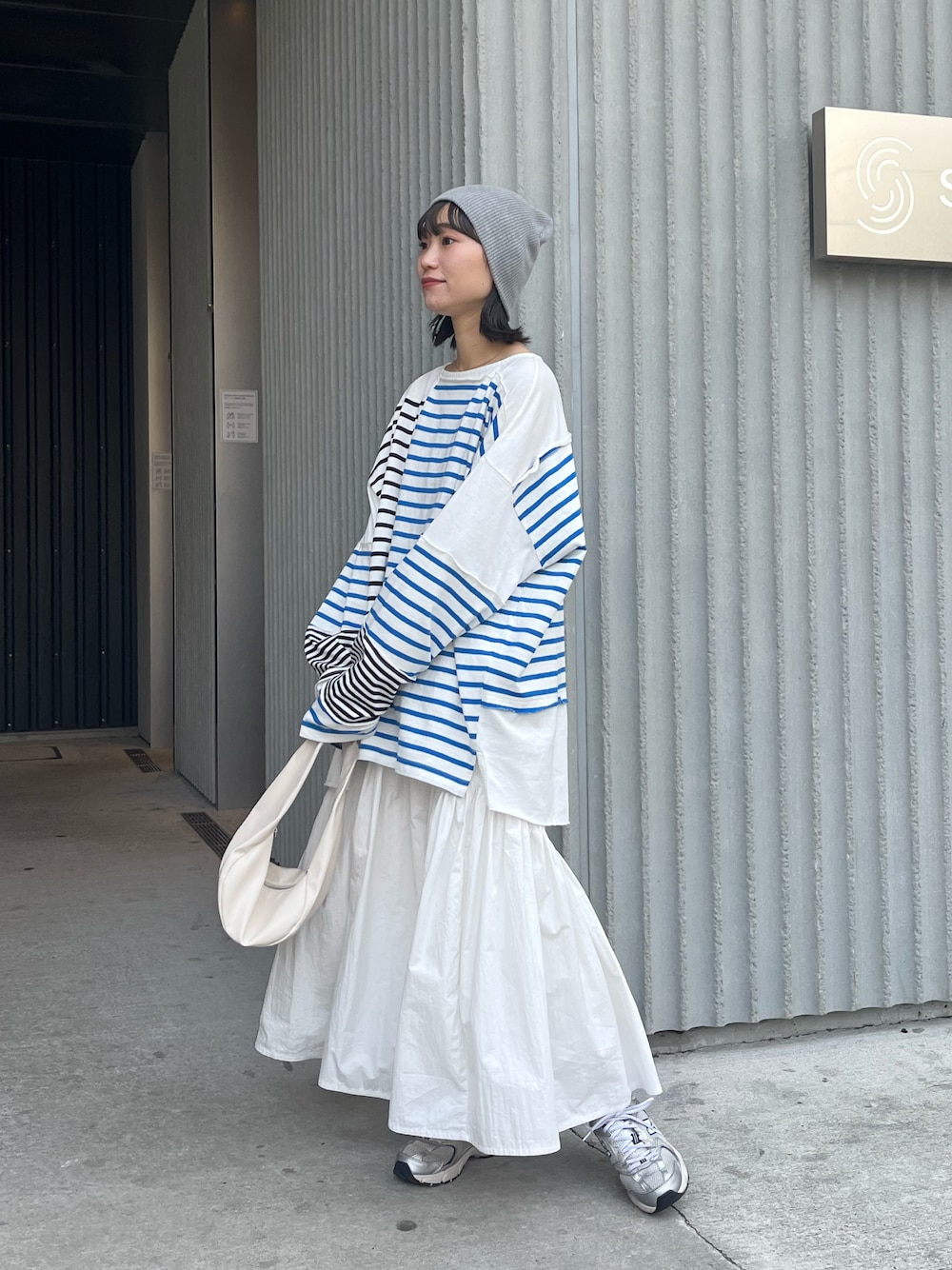 ブルー系のTシャツ/カットソー、ホワイト系のスカート、ホワイト系のハンドバッグを着用したレディースの春コーディネートの1枚目の写真