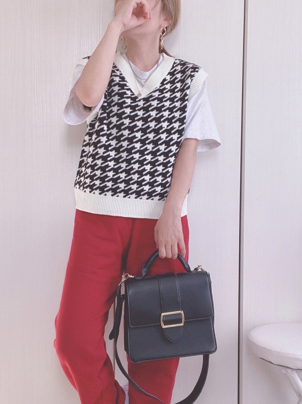 ブラック系のベスト、レッド系のスウェットパンツを着用したレディースの秋コーディネートの1枚目の写真