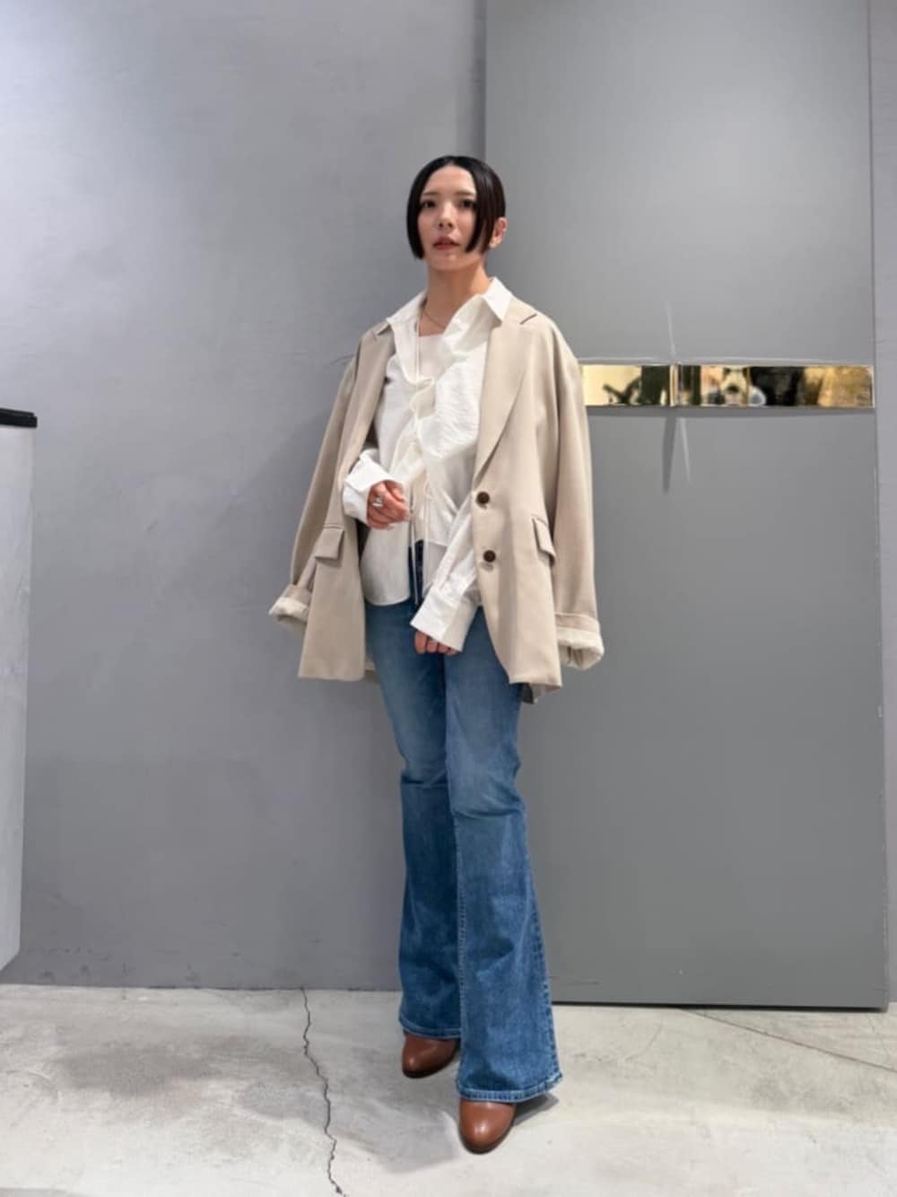 ブルー系のデニムパンツ、ホワイト系のシャツ/ブラウス、ベージュ系のテーラードジャケットを着用したレディースの春コーディネートの1枚目の写真