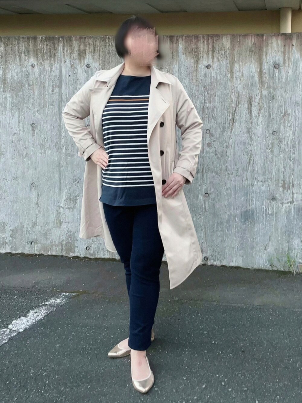 ベージュ系のトレンチコート、ブルー系のTシャツ/カットソー、ブルー系のデニムパンツを着用したレディースの秋コーディネートの1枚目の写真