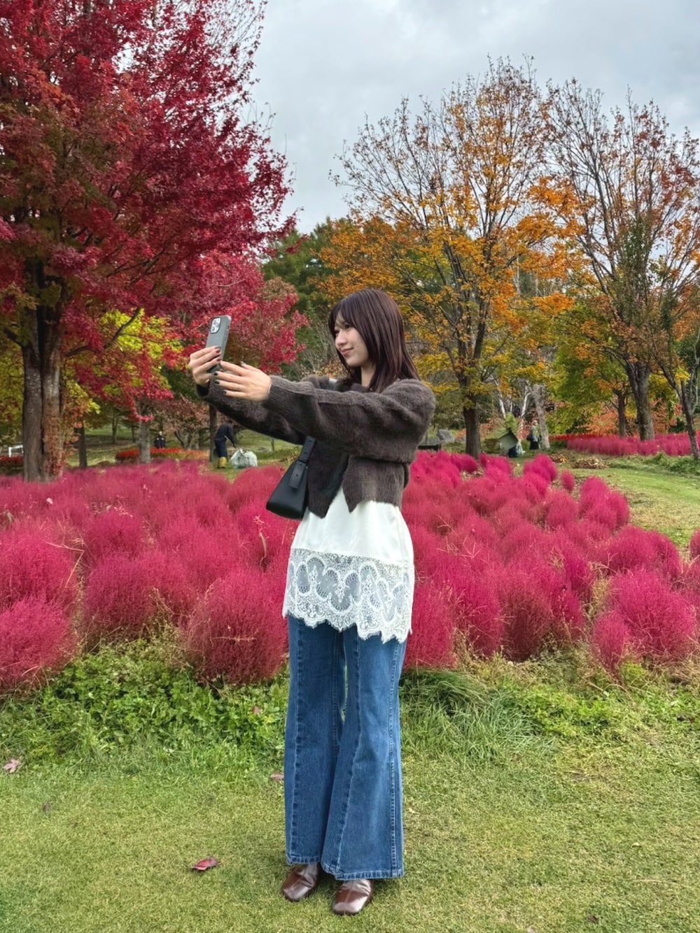 ブルー系のデニムパンツ、ホワイト系のシャツ/ブラウス、ブラウン系のブーツを着用したレディースの秋コーディネートの1枚目の写真