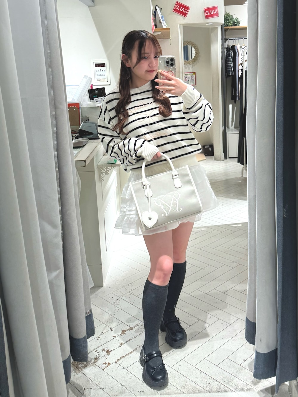 ブラック系のスニーカー、その他のニット/セーター、ベージュ系のトートバッグを着用したレディースの冬コーディネートの1枚目の写真