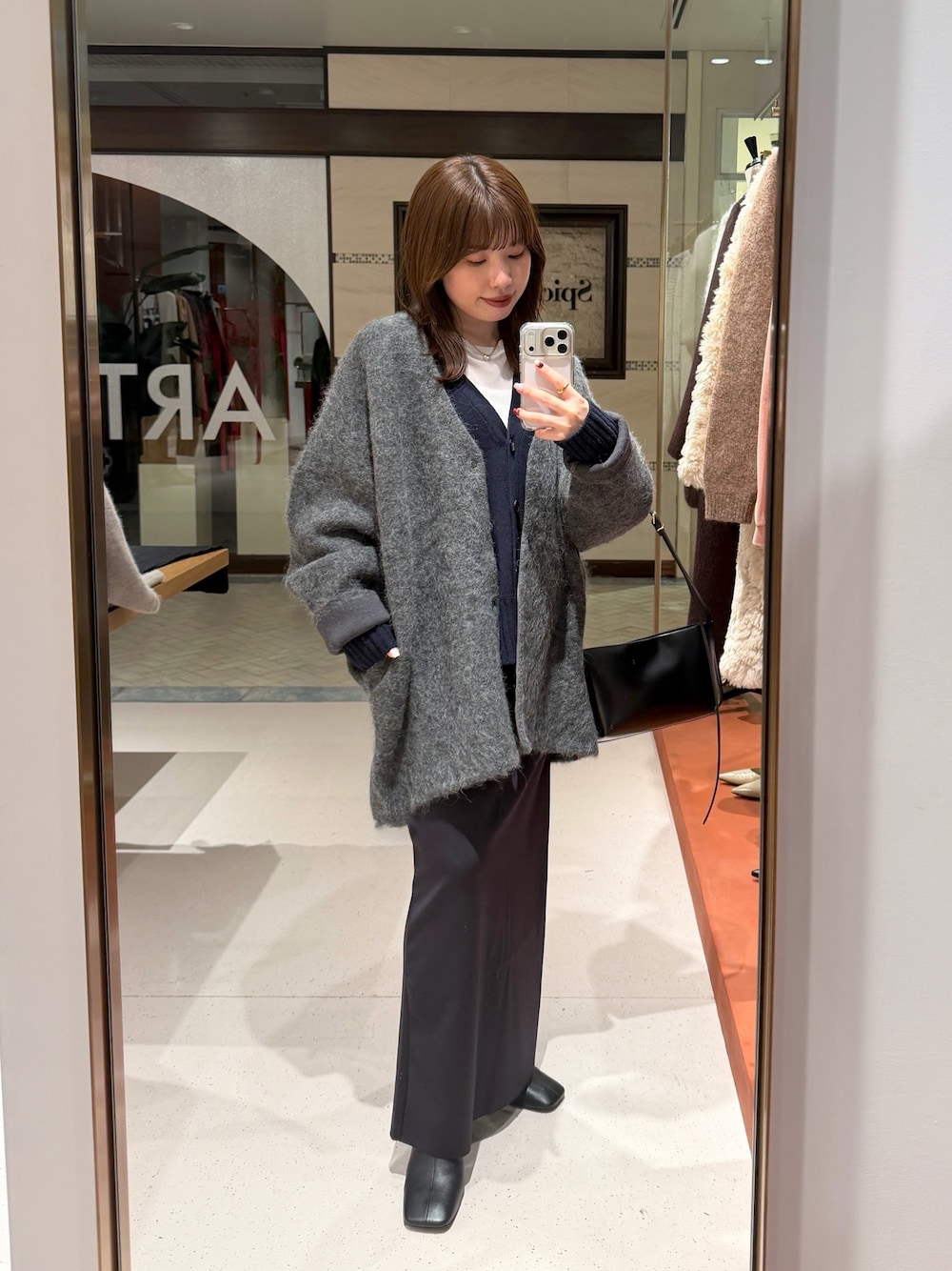 ホワイト系のTシャツ/カットソー、ブラック系のスカート、ブラック系のブーツを着用したレディースの秋コーディネートの1枚目の写真