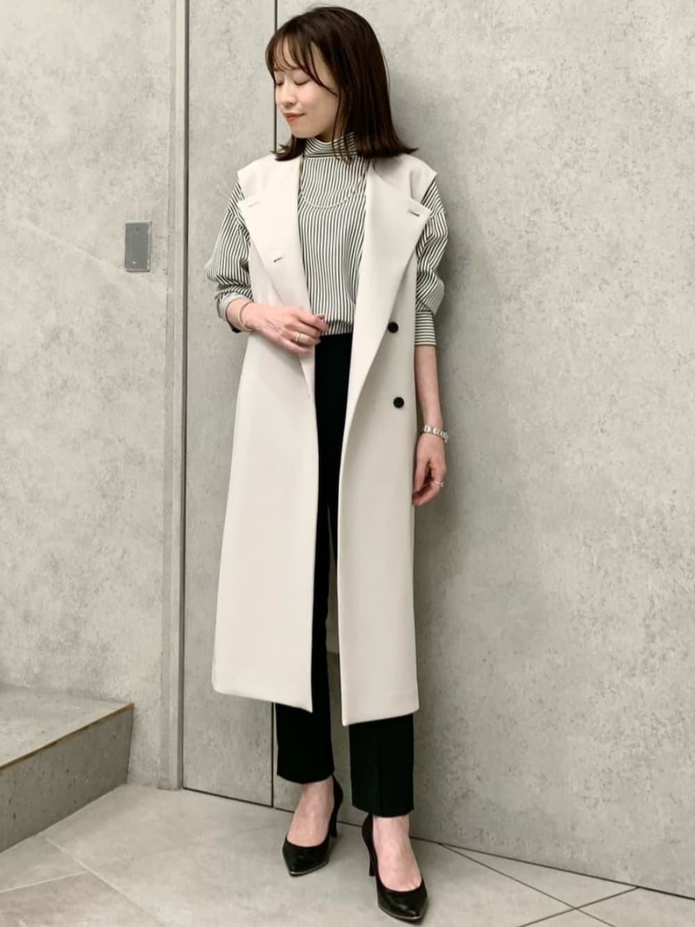 グリーン系のシャツ/ブラウス、ベージュ系のベストを着用したレディースの冬コーディネートの1枚目の写真