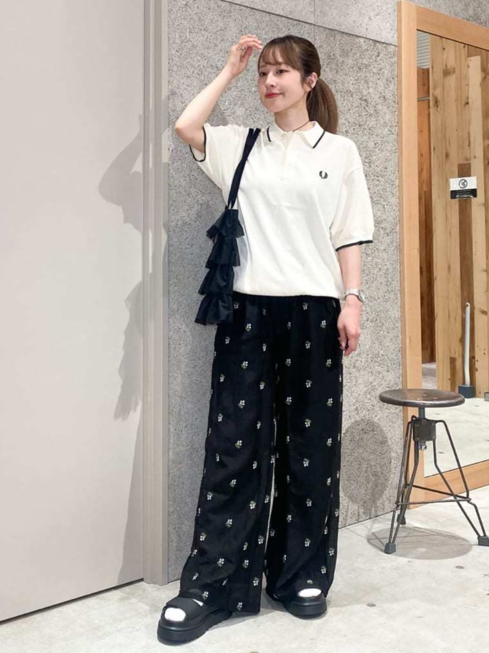 ブラック系のその他パンツ、ホワイト系のポロシャツを着用したレディースの夏コーディネートの1枚目の写真