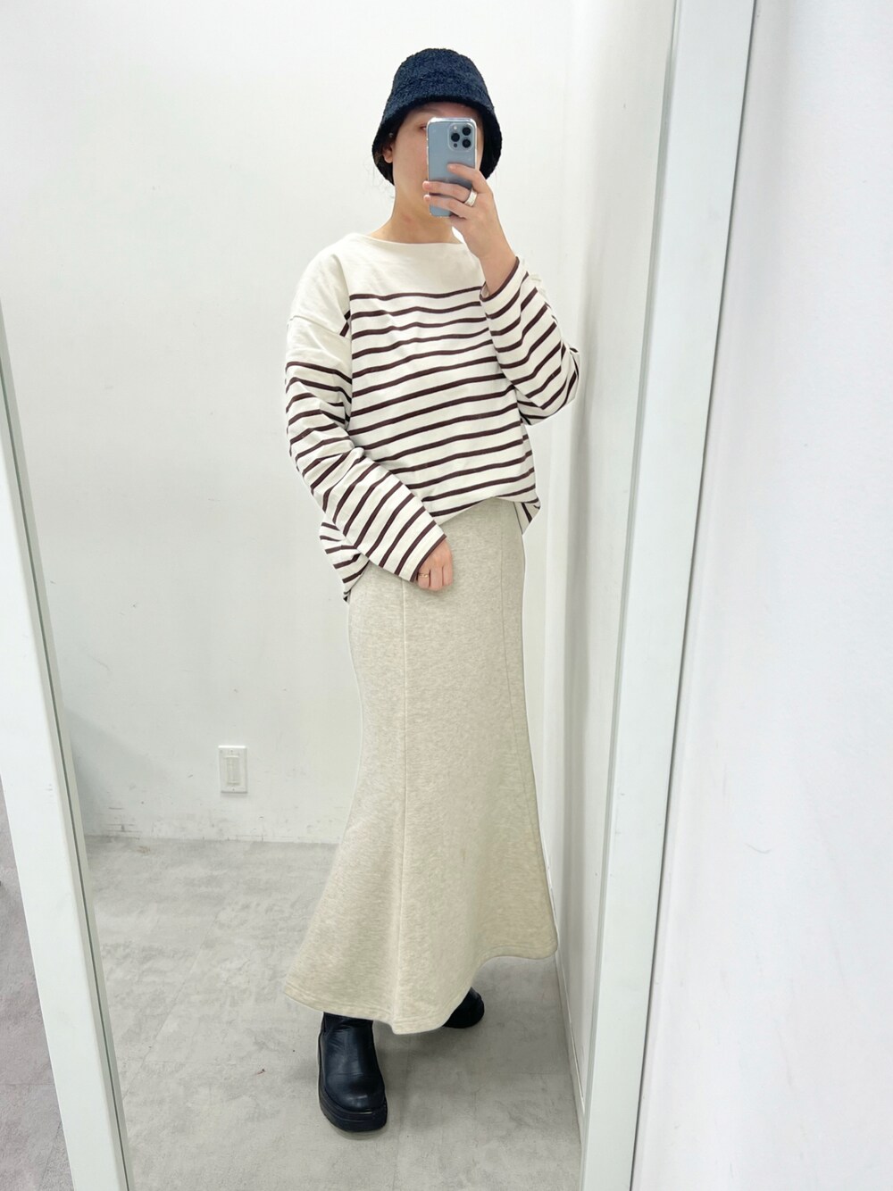 ブラック系のTシャツ/カットソー、ベージュ系のワンピース、ブラック系のブーツを着用したレディースの春コーディネートの1枚目の写真