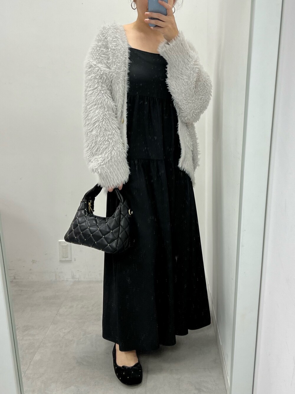 グレー系のカーディガン/ボレロ、ホワイト系のショルダーバッグ、ブラック系のバレエシューズを着用したレディースの冬コーディネートの1枚目の写真