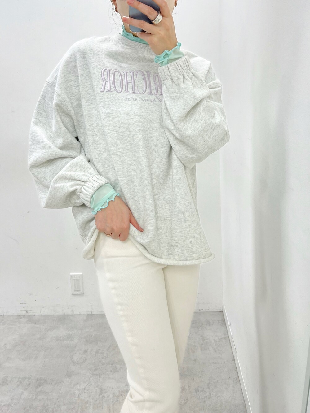 ベージュ系のスウェット、グリーン系のTシャツ/カットソー、ブルー系のデニムパンツを着用したレディースの春コーディネートの1枚目の写真
