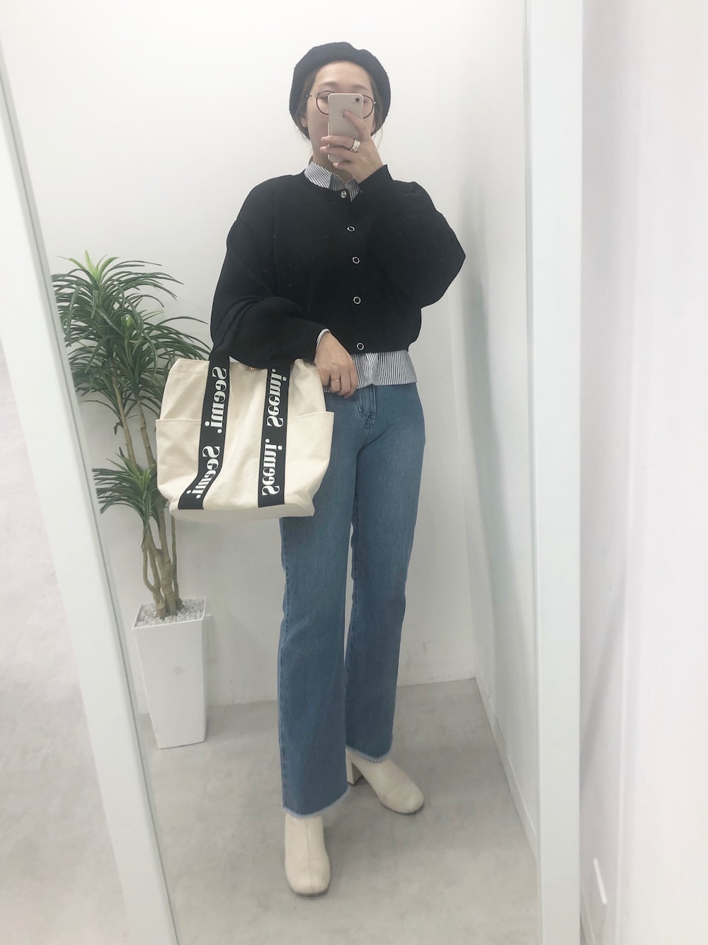 ブラック系のカーディガン/ボレロ、ブルー系のデニムパンツ、ホワイト系のブーツを着用したレディースの冬コーディネートの1枚目の写真