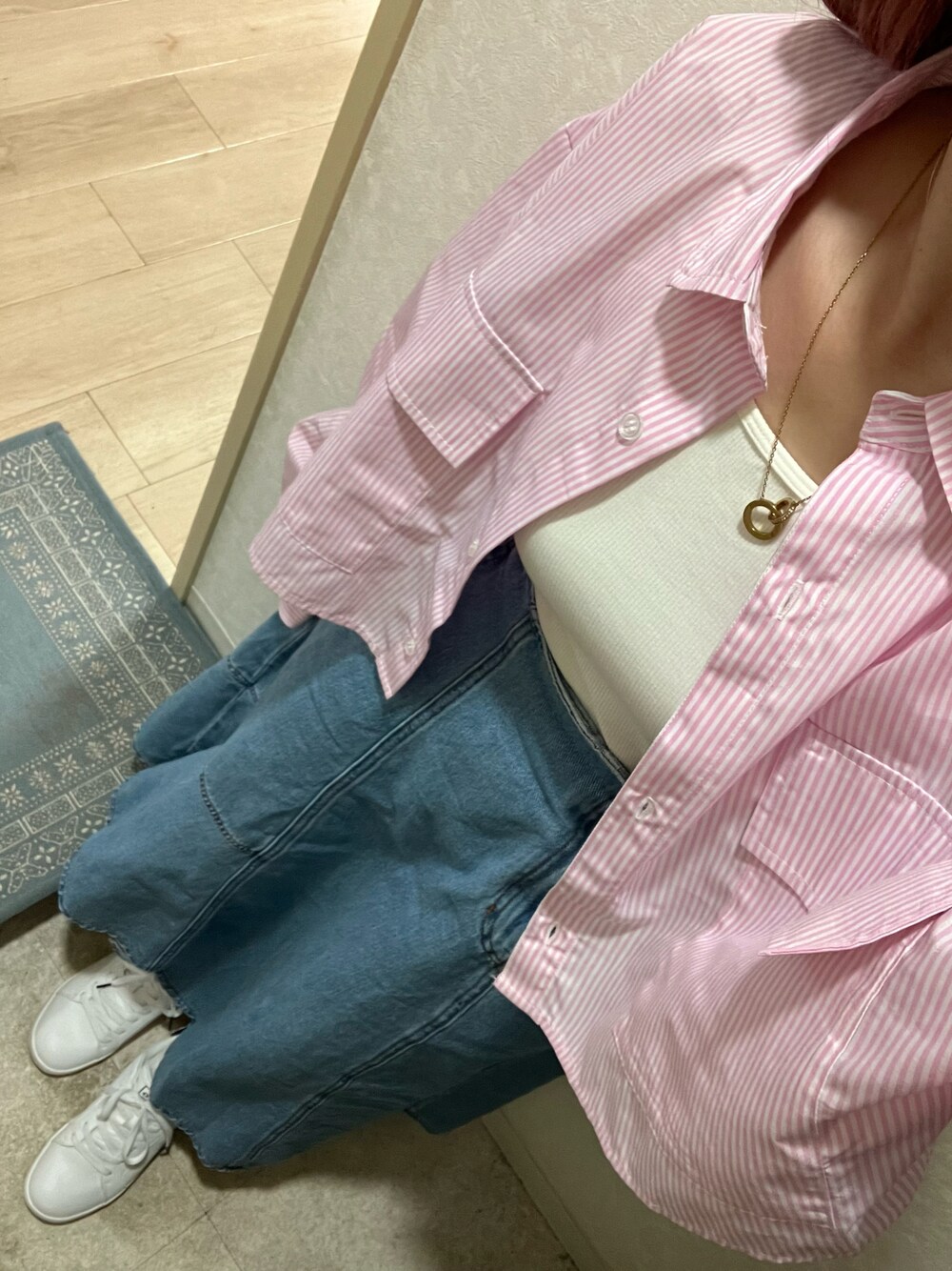 ブルー系のデニムスカート、ピンク系のシャツ/ブラウス、ホワイト系のスニーカーを着用したレディースの春コーディネートの1枚目の写真