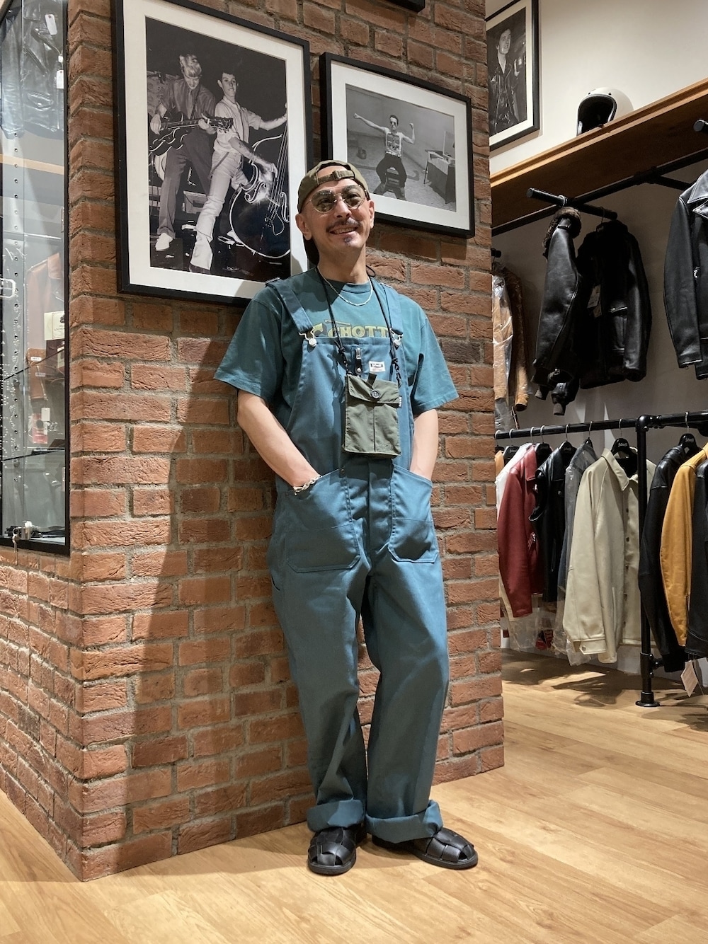 「メガネ男子、サングラス、オーバーオール、ロゴT、グルカサンダル、キャップ、ワントーンコーデ、グリーン、スクエアバッグ、ミニバッグ、セットアップ、ビッグシルエット、ストリート」｜「schottのSchott/ショット/GURKA SANDALS/グルカサンダル（サンダル、ブラック系）」を使った、総料理長（schottのイケオジ）さん（メンズ・170cm）の夏コーディネートの1枚目の写真