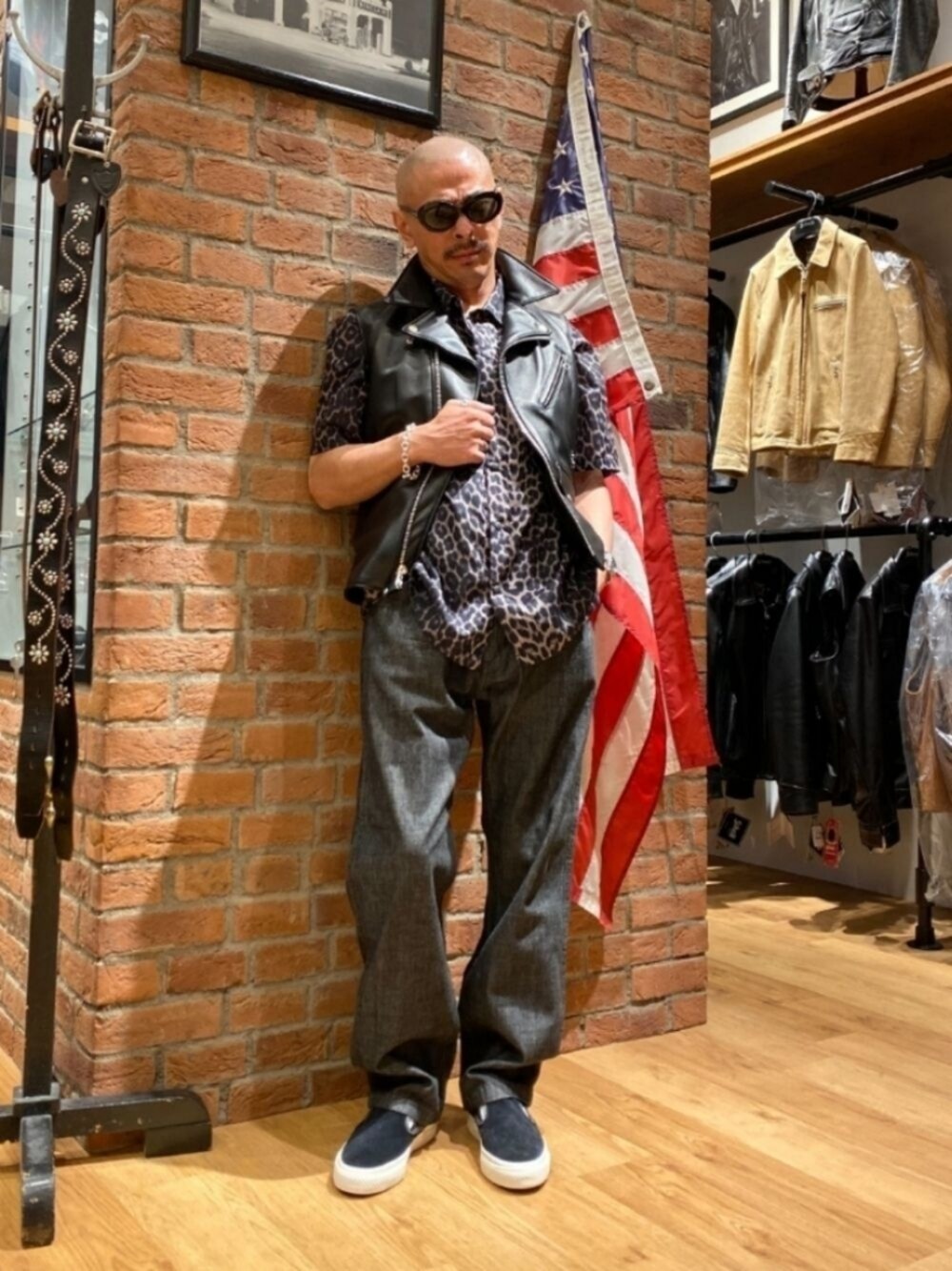 ブラック系のスリッポン、ブラック系のデニムパンツ、グレー系のシャツ/ブラウスを着用したメンズの夏コーディネートの1枚目の写真